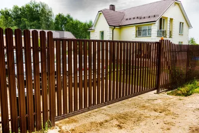 Забор из коричневого металлического штакетника с откатными воротами для  дачи от 58 635 р. — производство и установка заборов в Москве в компании  «Русские заборы»