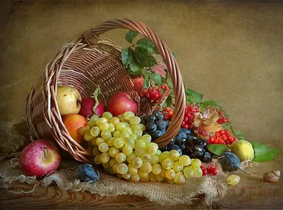 Фото Осенний натюрморт, фрукты и ягоды в корзине на столе