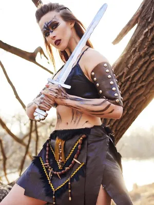Красивая женщина амазонки позирует с мечом | Премиум Фото