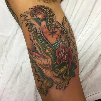 Тату крокодила с бутылкой на бицепсе парня — KissMyTattoo.ru