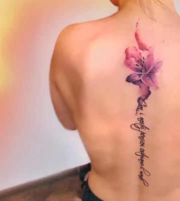 Тату лилия и надпись в акварели на спине у девушки - фото татуировок