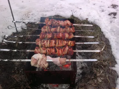 Готовим мясо на огне. шашлык на мангале. зимой гриль горит на улице. жарить  шашлыки на мангале | Премиум Фото
