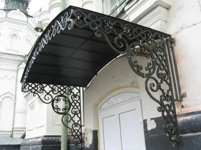 Металлический козырек над входной дверью с элементами ковки