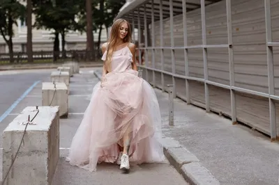 Девушка в длинном свадебном платье и кроссовках гуляет по городу летом |  Премиум Фото