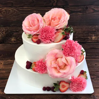 Двухъярусный торт с кремовым покрытием, цветами и ягодами на день рождения,  свадьбу или юбилей
