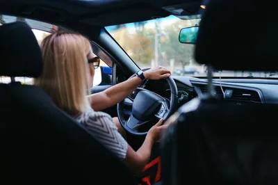 Selbstbewusste und schöne frau mit sonnenbrille. rückansicht der  attraktiven jungen frau in der freizeitkleidung, die ein auto fährt |  Kostenlose Foto