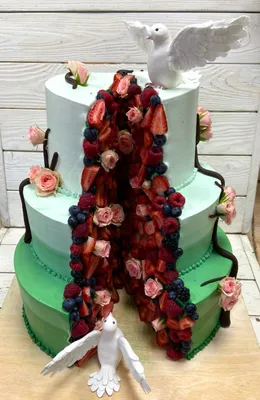 Трехъярусный торт из двух половин с ягодами, цветами и фигурками голубей