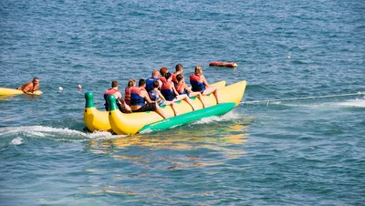 Туристы отпускников едут раздувной банан в море на горячий летний день  Редакционное Стоковое Фото - изображение насчитывающей группа, поплавок:  136689868