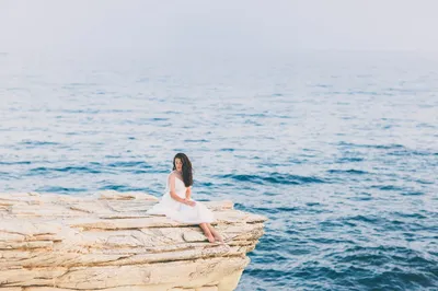 Обои девушка в красивом платье сидит на берегу моря