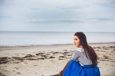 Девушка сидит на берегу моря фото фото