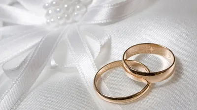 два золотых обручальных кольца со свадебными украшениями невесты на белом  фоне Stock-Foto | Adobe Stock
