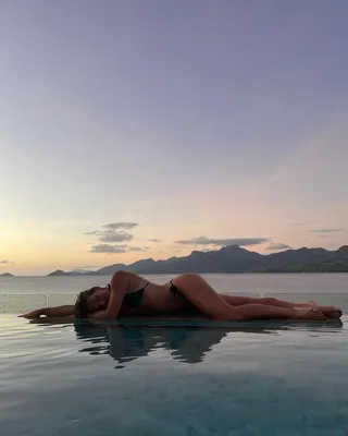 Красивая девушка в купальнике позирует на фоне океана на закате generative  ai | Премиум Фото