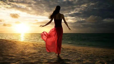 Женщина в бикини стоит на морском пляже на красивом закате | Премиум Фото