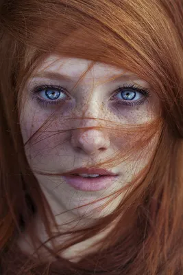 Женщина с рыжими волосами стоит на сером фоне. | Премиум Фото