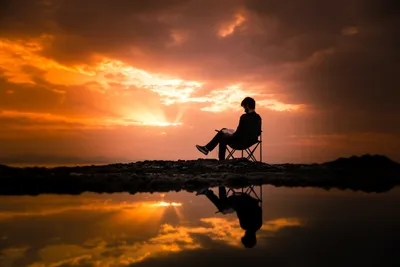 Фотография человека, сидящего на походном кресле на рассвете · Бесплатные  стоковые фото