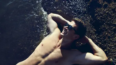 Красивый человек с солнечными очками и купальник наслаждаются на пляже на  заходе солнца Apulia, Salento, Италия Стоковое Фото - изображение  насчитывающей привлекательностей, смотреть: 149649036