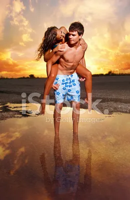 Счастливая влюбленная пара идет по воде на закате держась за руки Stock  Photo | Adobe Stock