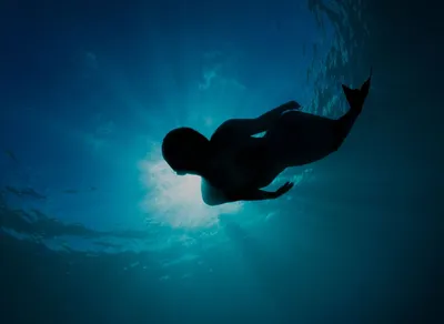 Женщина с хвостом русалки, счастливо плавающая во всю длину в бурлящей воде  | Хвост русалки