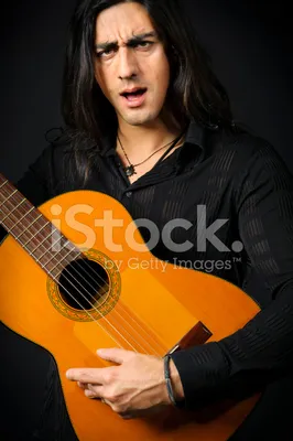 Молодой человек с длинными волосами с акустической гитарой | Премиум Фото