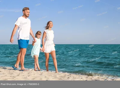 Счастливая семья усмехаясь на пляже Стоковое Изображение - изображение  насчитывающей лето, море: 142682807