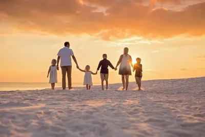 Силуэт счастливой семьи, играющей на пляже на солнце стоковое фото  ©altanaka 61601983