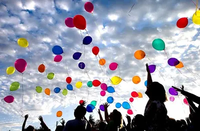 Фото Множество воздушных шаров в голубом небе, на переднем плане воздушный  шар в форме маяка