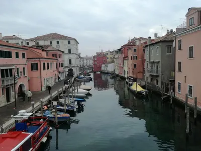 Кьоджа, венеция, италия: городской пейзаж с каналом, древний мост, лодки |  Премиум Фото
