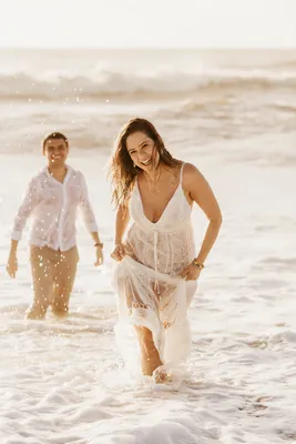 Красивые пары, имеющие удовольствие на пляже. Неунывающая девушка прыгнула  на парней назад Стоковое Фото - изображение насчитывающей напольно, океан:  196408910