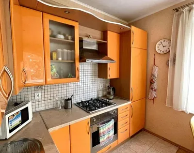 Белая угловая кухня со столешницей и кухонным фартуком под светлое дерево,  подсветкой рабочей зоны и реечным элементом - на заказ в Москве