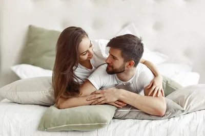 Premium Photo | Beautiful loving couple kissing in bed. beautiful young  couple lying together on the bed. romantic young couple in love lying on  bed. beautiful couple smiling in bed.