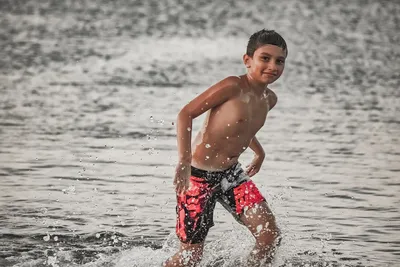 Загорелый мальчик играет на пляже Stock Photo | Adobe Stock
