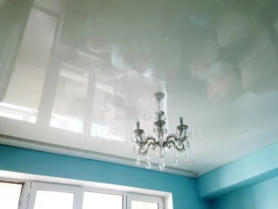 Белый матовый натяжной потолок с подсветкой штор в нише карниза в спальне
