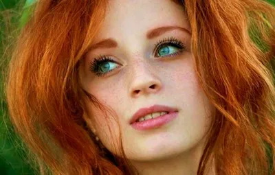 Женщина с рыжими волосами и голубыми глазами стоит среди листьев и смотрит  в камеру. | Премиум Фото
