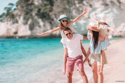 Счастливая молодая семья в белой одежде развлекается на отдыхе на красивом  пляже | Премиум Фото
