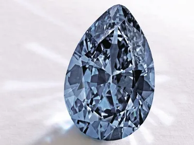 Синий бриллиант светится и стоит на камне на темном фоне | Премиум Фото