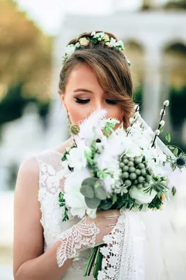 Выразительный свадебный макияж с накладными ресничками для синих глаз и  популярная греческая свадебная прическа с кудрями на бок и фатой для  блондинки
