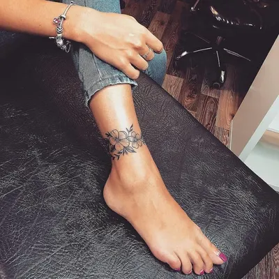 фото женской татуировки браслет с цветами на ноге в стиле блэковрк графика  перекрытие некачественной тату / Тату салон «Дом Элит Тату»