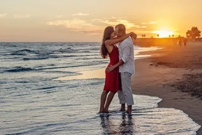 Пара на берегу моря смотрящая на закат. Stock Photo | Adobe Stock