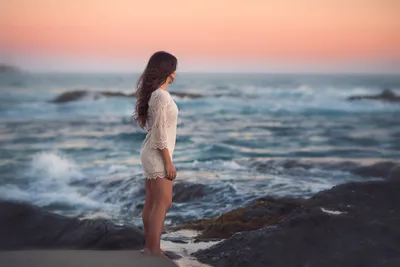 Красивая женщина стоит на берегу моря на закате, завернутые в одеяло,  смотрит вдаль Стоковое Изображение - изображение насчитывающей девушка, море:  202324937